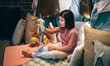 © David Pereiras - Adorable girl in pajamas playing alone with teddies in a play shelter made of bed sheets and chairs