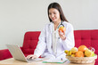 © DG PhotoStock - Happy Asian nutritionist working in her office in hospital.