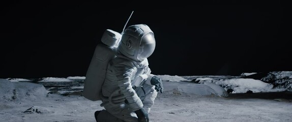 cu portrait of caucasian female lunar astronaut finds something and kneels while exploring moon surf