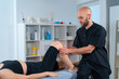 © ADDICTIVE STOCK - Physical therapist examining leg of crop sportswoman in hospital