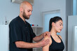 © ADDICTIVE STOCK - Physiotherapist examining shoulder of sportswoman in hospital