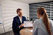 © Drazen - Happy entrepreneur analyzing business chart with female colleague in the office.