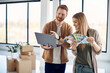 © Drazen - Smiling couple using laptop while choosing color from palette during home renovation.