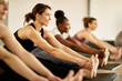 © Drazen - Young happy athletic woman stretching during exercise class at health club.