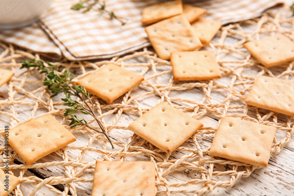 Tasty crackers on light wooden background, closeup