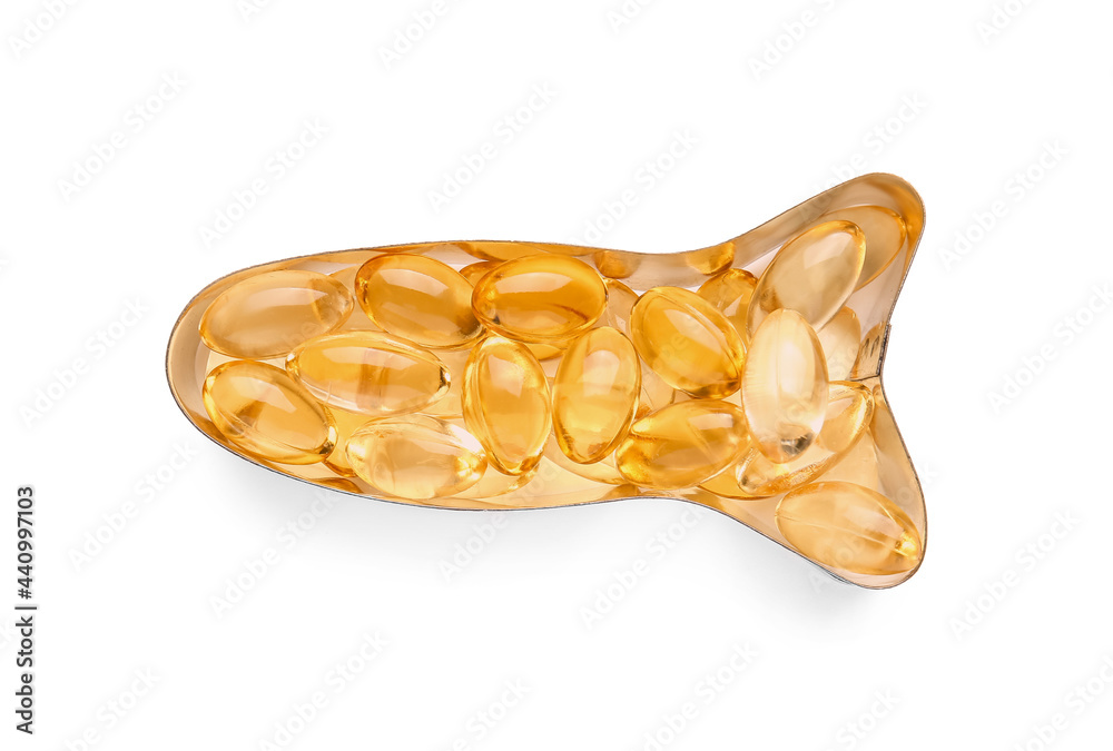 Fish shaped plate with oil capsules on white background