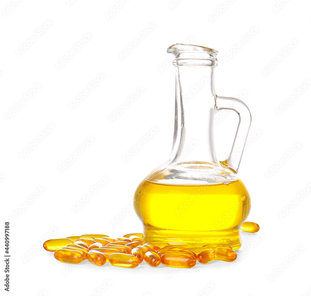 Jug of fish oil and capsules on white background