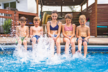 group of children having fun in Pool on the summer time