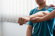 © amnaj - Physiotherapist treating a man with elbow pain at a clinic.
