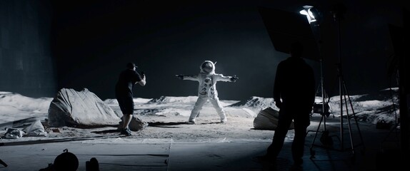 Wall Mural - wide behind the scenes, cinematographer shooting viral video for social account on a large moon land