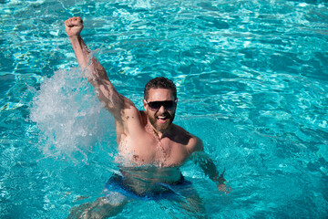 Man in pool. Summer weekend and vacation. Handsome man in swimming pool. Pool party. Resort.