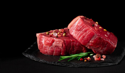 Beef steak, raw, mignon, with spices, on a black background, horizontal, no people,