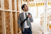 Male Architect Inspecting Framing At House Construction Site