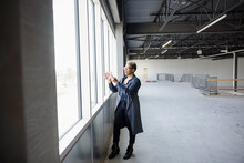 Professional Woman Taking Photo In Empty Warehouse