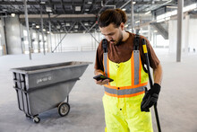 Labourer On Phone In Empty Warehouse