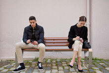 strangers sitting on a bench with distance