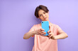 © alfa27 - Attractive woman with short hair take photo on mobile phone, make selfie with serious face, posing isolated on purple background. portrait