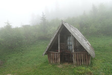 Abandoned Wooden Cabin In A Misty Forest. Summer Foggy Mysterious Landscape            
