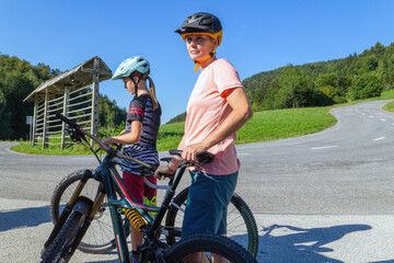 Wall Mural - Mother and daughter cyclist resting on a country road.