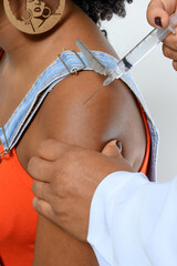 Wall Mural - SUPER CLOSE-UP PHOTO OF A GIRL BEING VACCINATED IN THE ARM BY A HEALTH PROFESSIONAL