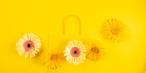 Canvas Print - Yellow flat paper shopping bag with gerbera daisy flowers on monochrome background