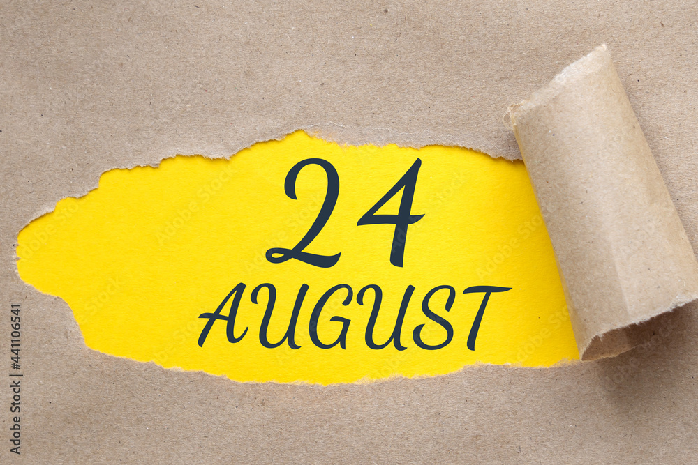 august 24. 24th day of the month, calendar date.Hole in paper with edges torn off. Yellow background is visible through ragged hole.Summer month, day of the year concept
