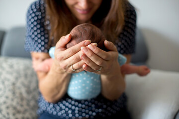 Poster - Young mother, holding tenderly her newborn baby boy