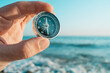 © Alex Photo - Man traveler holds a compass in his hand. In the background is a seascape. Close-up on a man's hand.