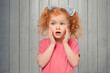 Shocked and scared redhead little girl 4-6 years old, staring startled at left and frightened, afraid of something scary