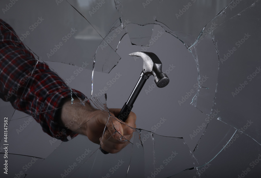 Man breaking window with hammer on grey background, closeup - obrazy, fototapety, plakaty 