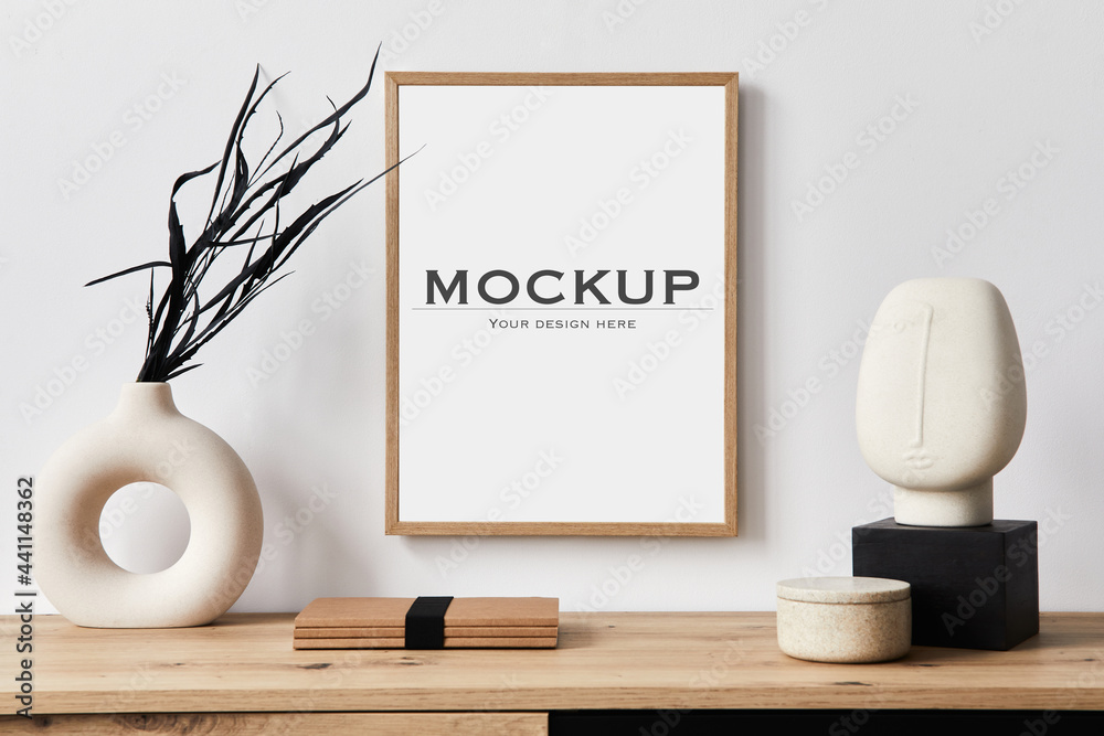 Stylish interior of living room with mock up poster frame, wooden commode, book, black leaf in ceramic vase and elegant personal accessories. Minimalist concept of home decor. Template. - obrazy, fototapety, plakaty 