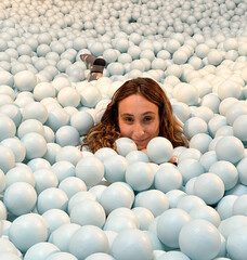 young woman lying in a plastic ball pool, fun, laughter, life.Life health concept.