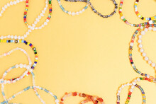 Necklaces And Bracelets Made From Beads And Pearls On A Golden Background. Border Frame With Copyspace.