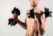 © Yevhen - Man holding dumbbell in hand. Skinny guy hold dumbbells up in hands. A thin man in sports with dumbbells. Weak man lift a weight, dumbbells, biceps, muscle, fitness. Nerd maleraising a dumbbell