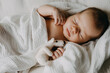 © Bostan Natalia - Newborn baby sleeping hugging a white bear toy.