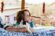 © Mint Images - Young boy lying on outdoor bed stroking a pet cat