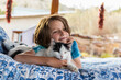 © Mint Images - Young boy lying on outdoor bed stroking a pet cat