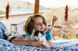 © Mint Images - Young boy lying on outdoor bed stroking a pet cat