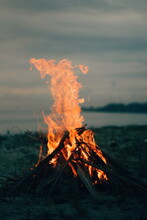 Bonfire On Wooden Log At Beach