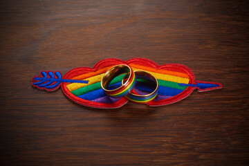 Love wins concept with a multicolored heart and wedding rings. Equality and love protection