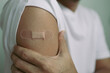 © anut21ng Stock - man showing plaster on arm after vaccination