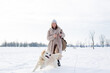 © Zhuravleva Katia - Young beautiful woman and her golden retriever dog having fun in winter.