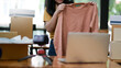 © sarawutnirothon - Women show selling shirts online from home. She uses her laptop to sell on social media. Online shopping concepts.