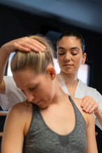 Physiotherapist Fitting Shoulder Joint Of Woman