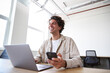 © Southworks - Young man with laptop and mobile phone at desk working on start up business in open plan office