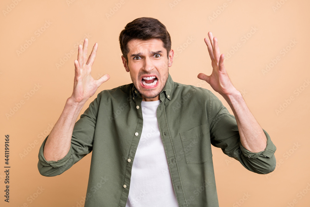 Photo of shocked aggressive young annoyed man raise hands bad mood isolated on beige color background - obrazy, fototapety, plakaty 