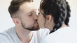 © LIGHTFIELD STUDIOS - young woman with braids and man kissing at home.