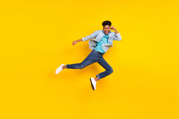 Wall Mural - Photo of strong cool dark skin guy dressed denim shirt practicing karate jumping high isolated yellow color background