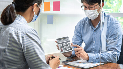 Wall Mural - Asian business man showing investment amount on calculator to partner and discussion about new project