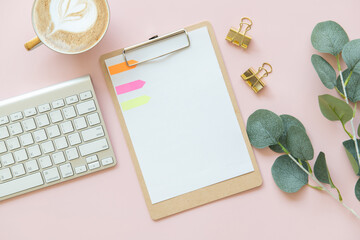 pink office desk table with blank paper mockup, Paper clip, Clipboard, Eucalyptus leaf, post-it. Top view with copy space, flat lay. Pastel.